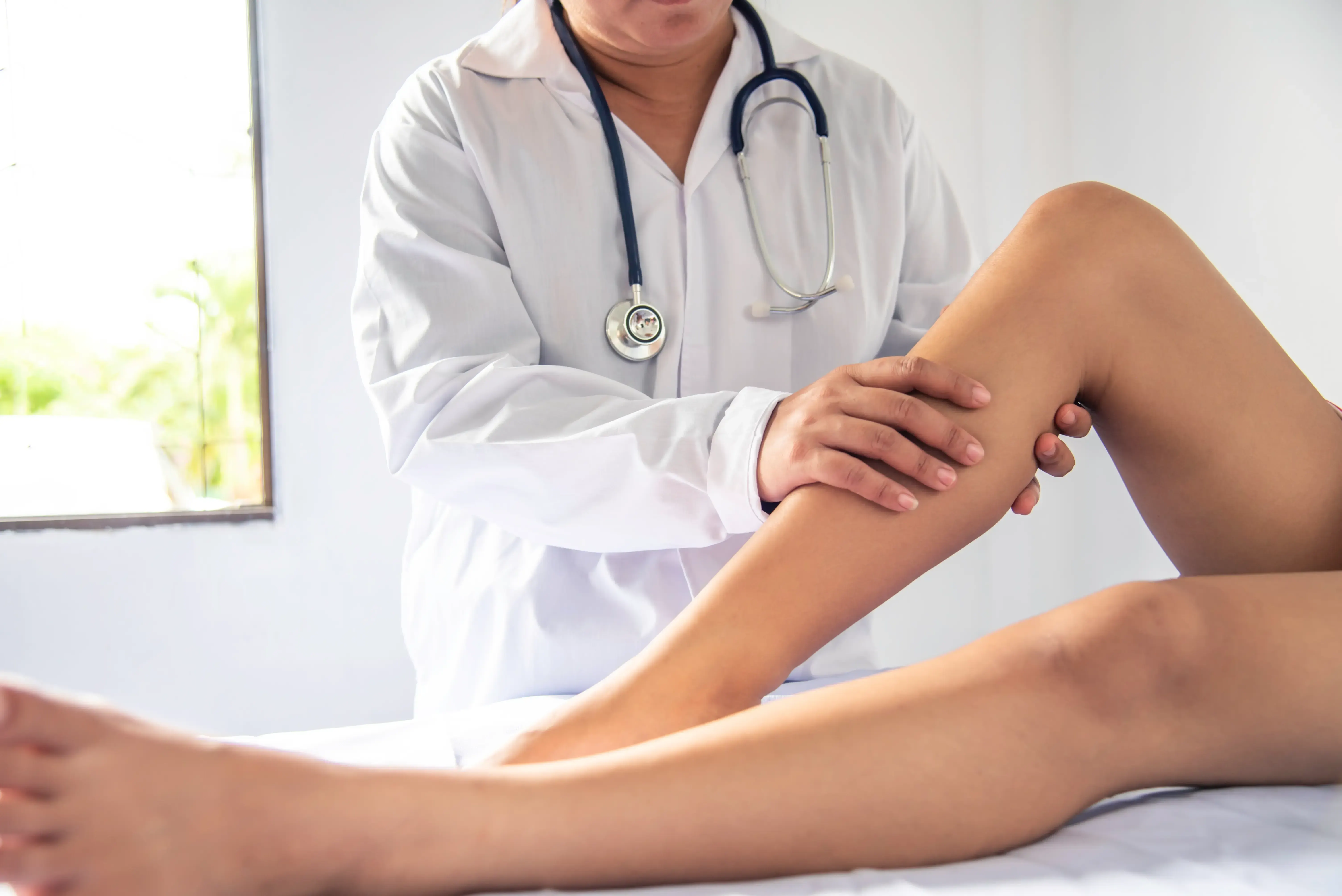 Board-certified vein specialist evaluating a patient's legs for vein treatment at a Suwanee, GA vein clinic