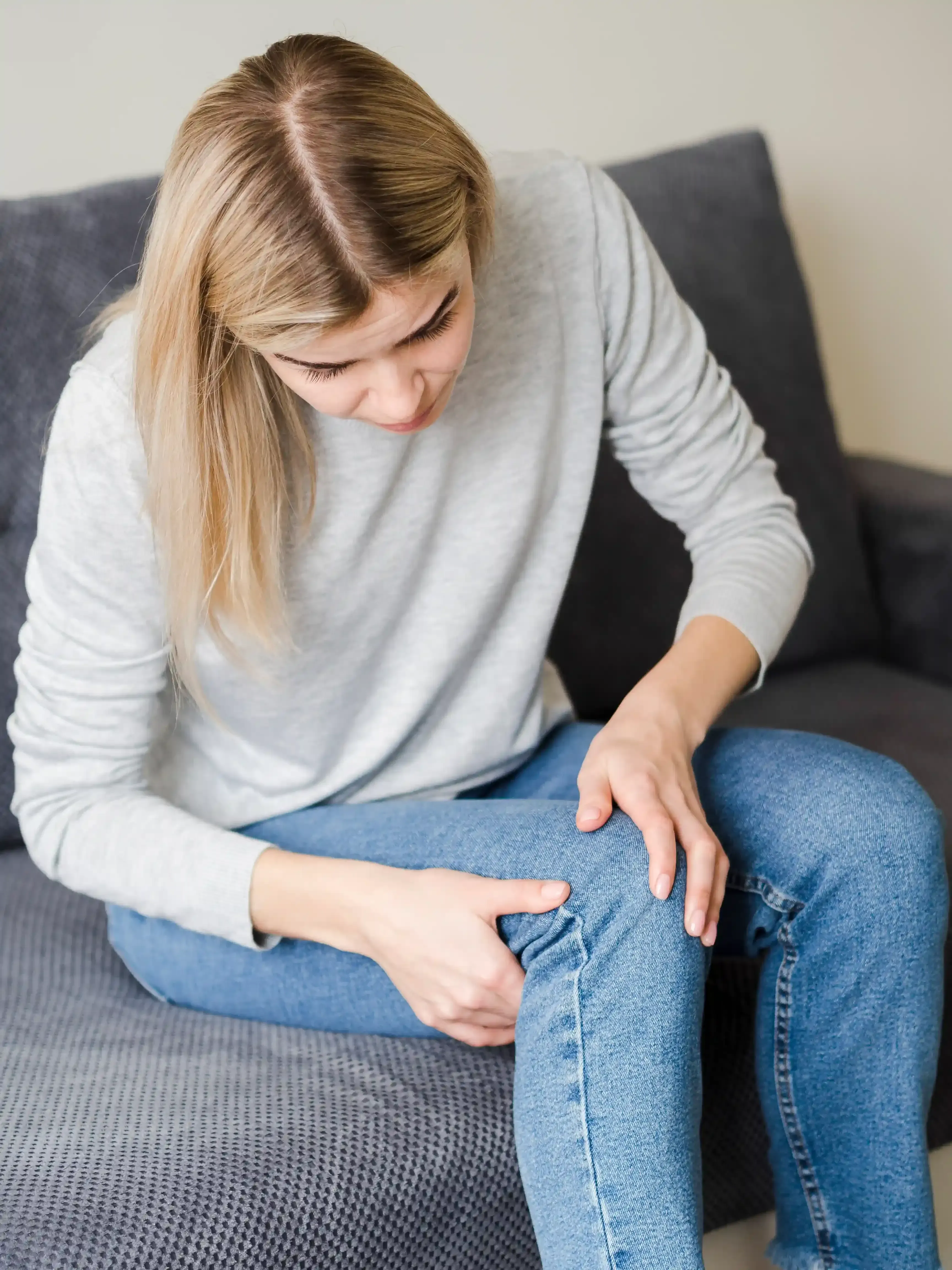 Person checking noticeably swollen ankles that feel heavy, tight, and achy by the end of the day