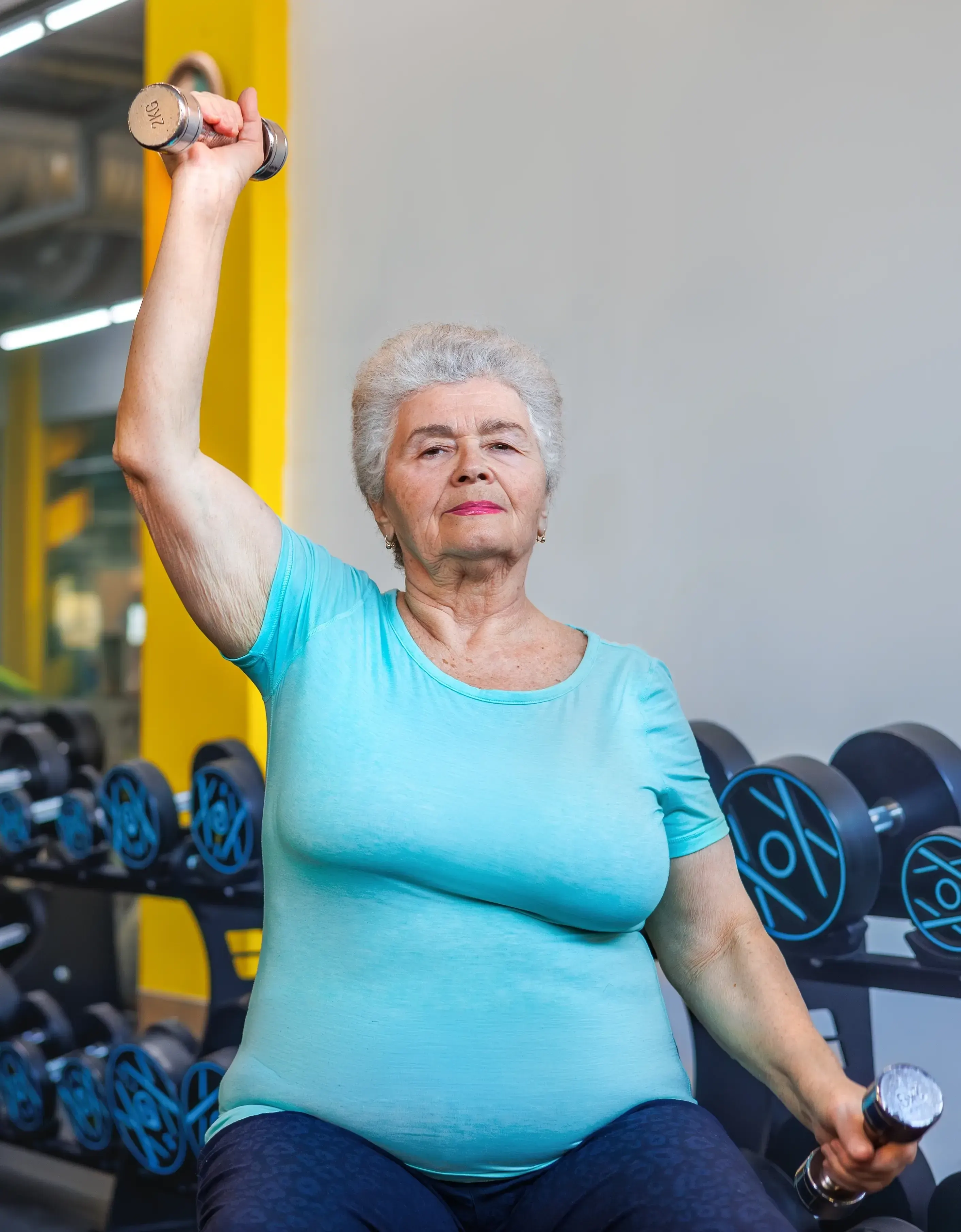 Older woman climbing stairs with effort, representing how age-related muscle loss affects daily strength and mobility